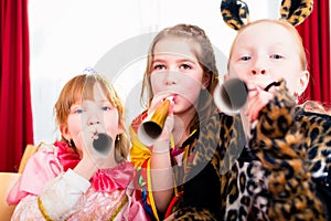 Kids with noisemakers making noise on party