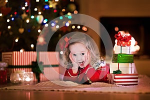 Kids opening Christmas presents at fireplace