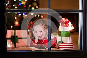 Kids opening Christmas presents at fireplace