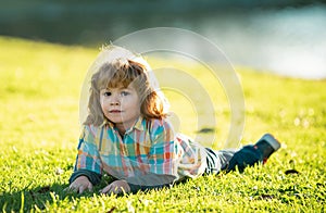 Kids outdoor. Children in park. Spring Boy lying on grass. Summer walk. Children adaptation.