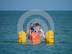 Kids with paddle boat on the ocean