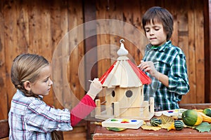 Kids painting the bird house for the winter