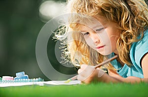 Kids painting with paints color and brush in park outdoor. Children hobby, happy childhood. Kid pupil learning painting.