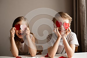 Kids painting red valetine heart card on table at home