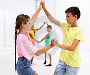 Kids in pairs exercising salsa moves