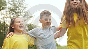Kids in the park. Group of children a hugging rejoices and jumping in the park in nature outdoors. Happy family kids in