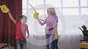 Kids party, funny little ones friends fight with air balloons during active childrens games