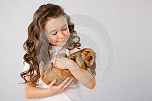 Kids pet friendship concept - little girl with red puppy isolated on white background