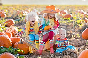 Kids picking pumpkins on Halloween pumpkin patch