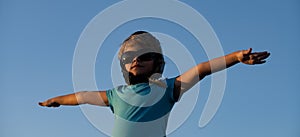 Kids with pilot goggles and helmet playing with vintage wooden airplane outdoors. Portrait of children against summer