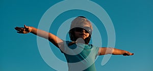 Kids with pilot goggles and helmet playing with vintage wooden airplane outdoors. Portrait of children against summer