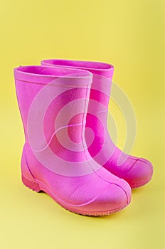 Kids pink rubber boots EVA on a yellow background