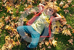 Kids play in autumn park. Children portrait with yellow leaves. Child boy with oak and maple leaf outdoor. Fall foliage