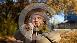 Kids play in autumn park. Children throwing yellow leaves. Child boy with oak and maple leaf outdoor. Fall foliage