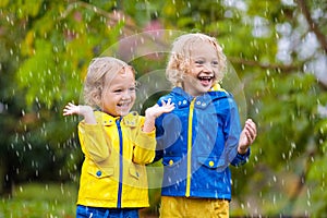 Kids play in autumn rain. Child on rainy day