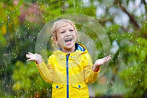 Kids play in autumn rain. Child on rainy day