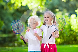 Kids play badminton or tennis in outdoor court