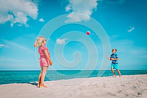 Kids play with ball on beach, boy and girl have fun at sea