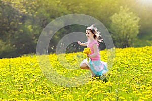 Kids play. Child in dandelion field. Summer flower