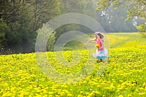 Kids play. Child in dandelion field. Summer flower