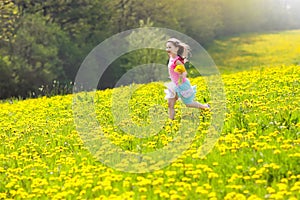 Kids play. Child in dandelion field. Summer flower