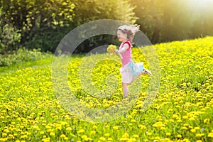 Kids play. Child in dandelion field. Summer flower