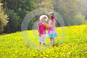 Kids play. Child in dandelion field. Summer flower