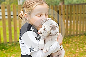 Kids play with cute little puppy. Children and baby dogs playing in sunny summer garden. Little girl holding puppies