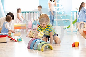 Kids play on floor with educational toys. Toys for preschool and kindergarten. Children in nursery or daycare photo