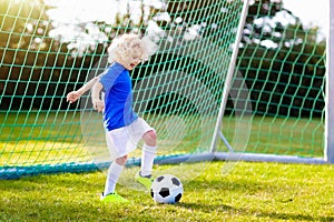 Kids play football. Child at soccer field.