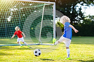 Kids play football. Child at soccer field.