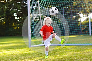 Kids play football. Child at soccer field.