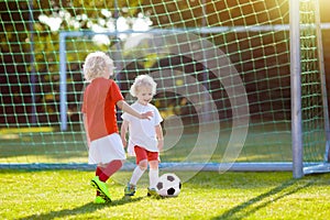 Kids play football. Child at soccer field.