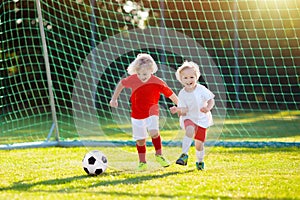 Kids play football. Child at soccer field.