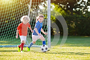 Kids play football. Child at soccer field.