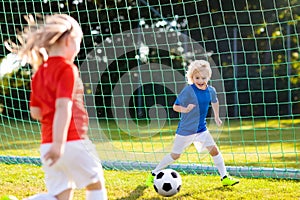 Kids play football. Child at soccer field.