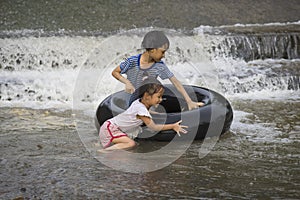 a kids play and lying on a tire floating in water Filmed in Chiang mai, Thailand