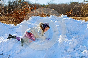 Kids play outside winter season Happy kid playing in the snow near a forest