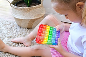 Kids play with pop it sensory toy. Stress and anxiety relief. Trendy silicon fidgeting game for stressed children