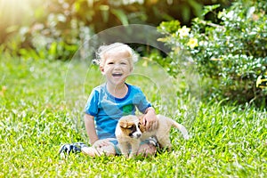 Kids play with puppy. Children and dog in garden.