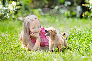 Kids play with puppy. Children and dog in garden.