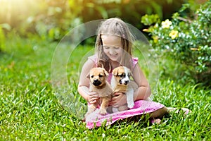 Kids play with puppy. Children and dog in garden.