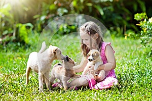 Kids play with puppy. Children and dog in garden.