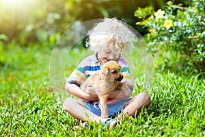 Kids play with puppy. Children and dog in garden