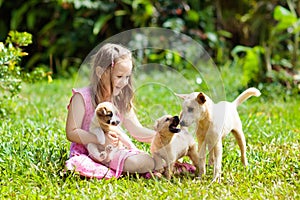 Kids play with puppy. Children and dog in garden