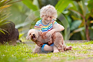 Kids play with puppy. Children and dog in garden