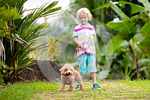 Kids play with puppy. Children and dog in garden