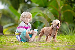 Kids play with puppy. Children and dog in garden