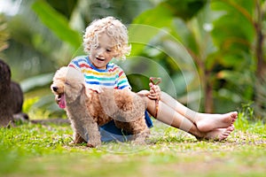 Kids play with puppy. Children and dog in garden