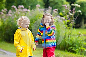 Kids play in rain and puddle in autumn